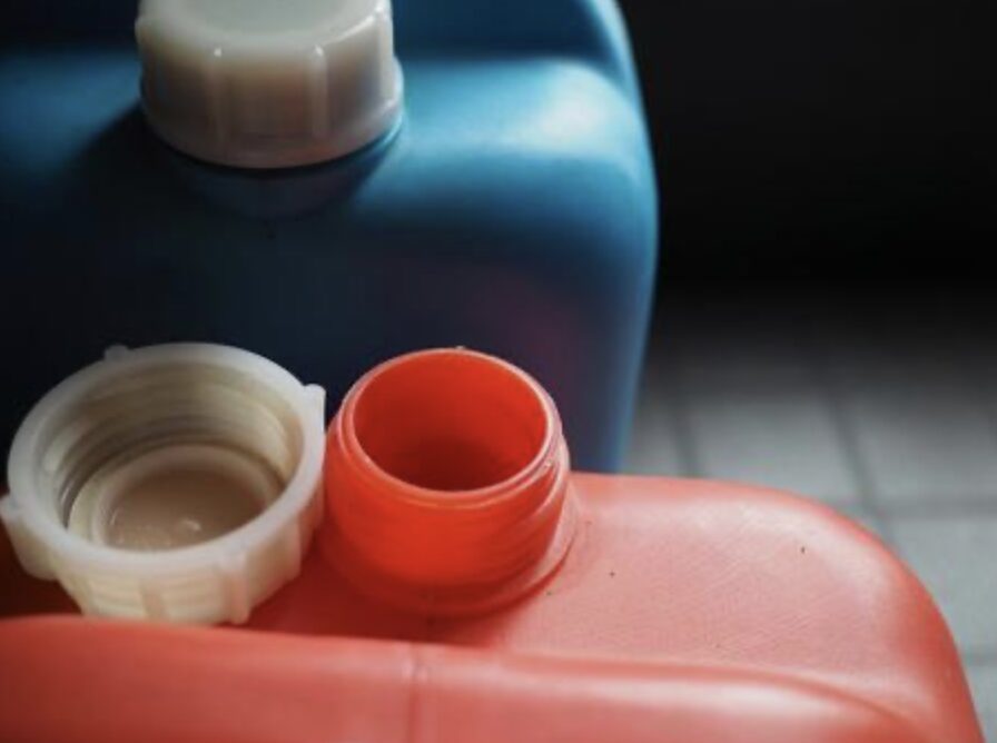 赤と青のポリタンクが並び、手前の赤いポリタンクはキャップが外れて注ぎ口が見えている様子を写した写真