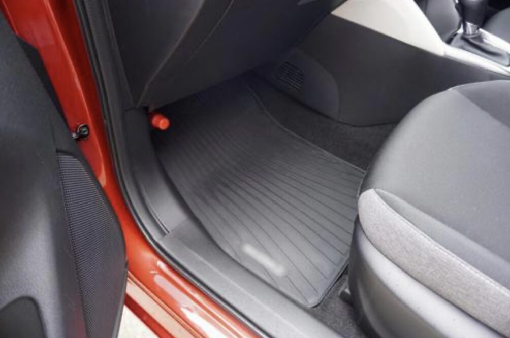 車の助手席足元スペースを写した写真で、黒いラバーマットが敷かれている様子が見える。