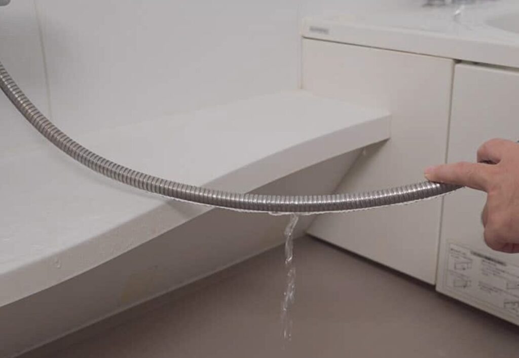 シャワーホースが水漏れしている様子。かなり水が滴っている。