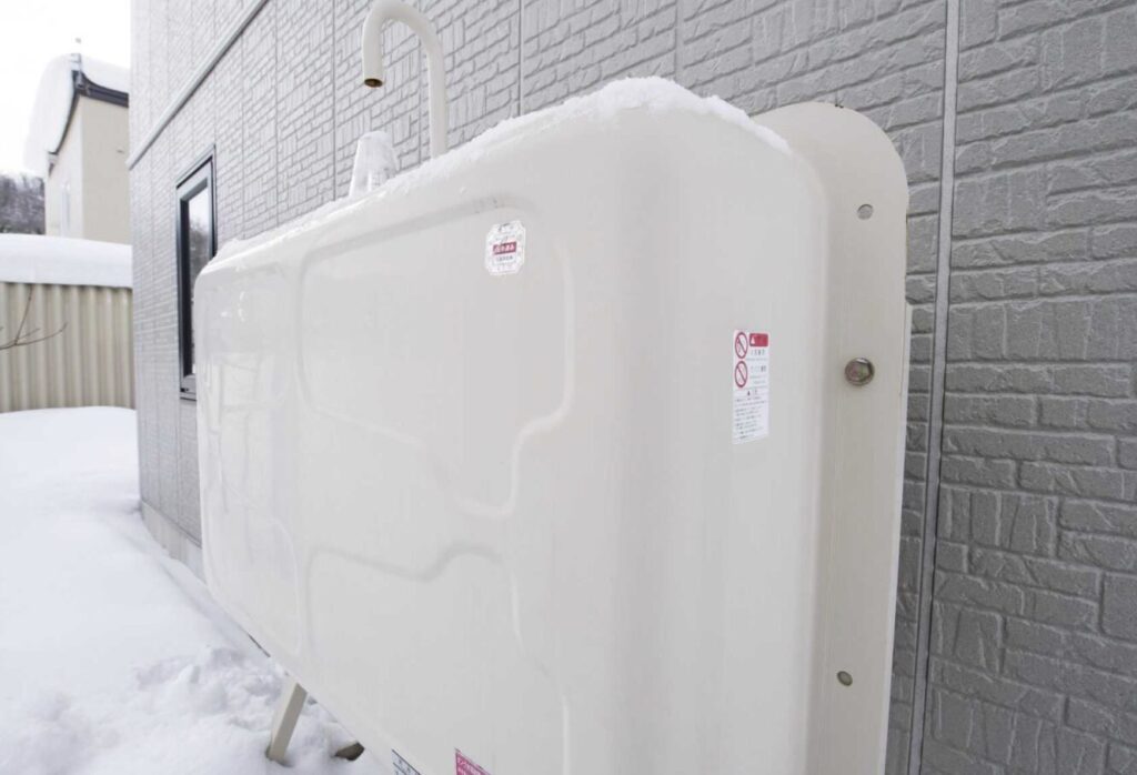 雪の中に設置されている灯油タンク。雪が積もっている状態。