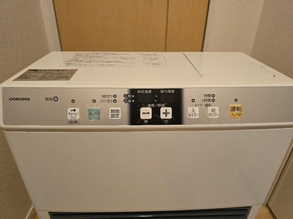 コロナ製石油ストーブの操作パネルを正面から撮影した様子。運転入切ボタン、eco表示、温度と時刻の設定操作部が横一列に配置されている。