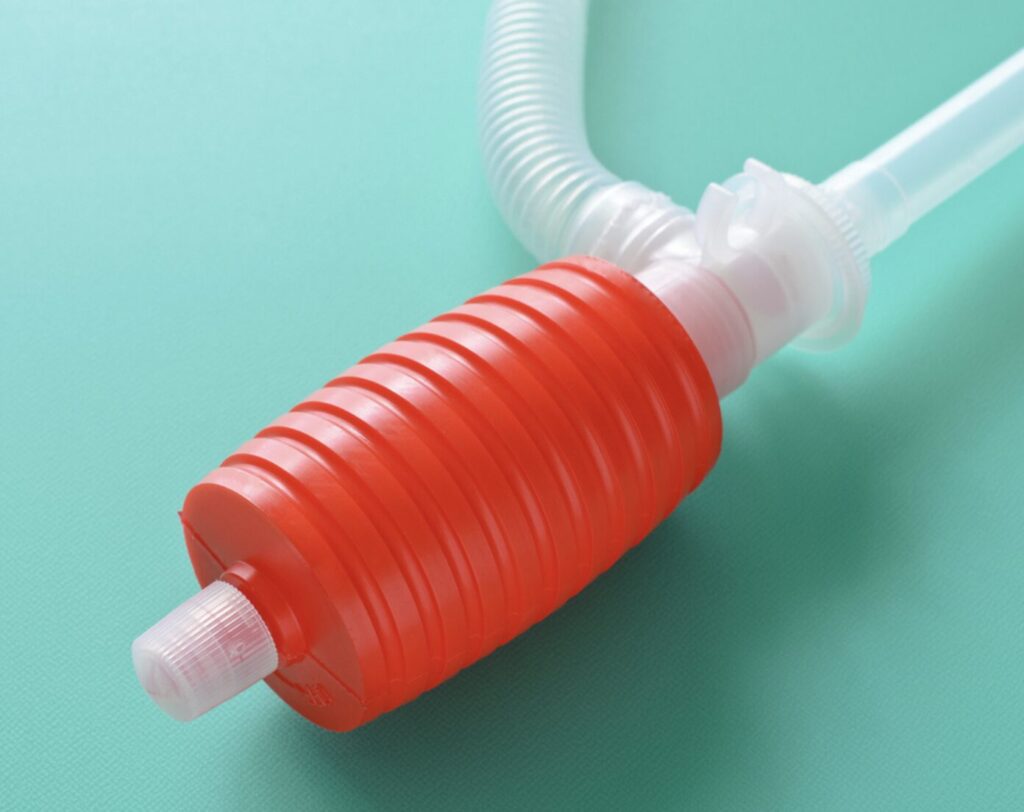 灯油ポンプを拡大した写真。赤いポンプ部分と白いエア抜きキャップが目立っている