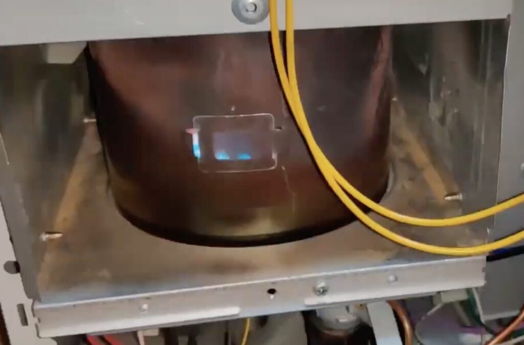 コロナ製ファンヒーターを分解し、燃焼試験をしている様子。青い炎が見え、燃焼している様子がわかる。