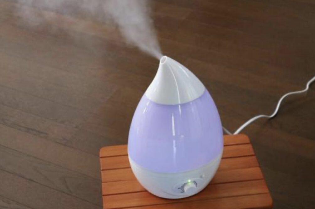 木製の台の上に置かれたしずく型の加湿器から、上方向に細かなミストが噴き出している使用中の様子
