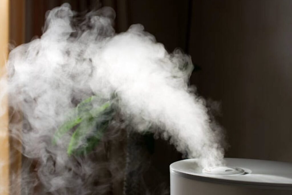 室内に設置された加湿器の吹き出し口から、白く濃いミストが勢いよく噴き出し、空気中に広がっている様子
