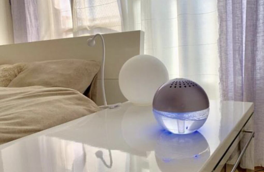 ベッド横のサイドテーブルに置かれた球形の加湿器が、やわらかな光を放ちながら寝室の空気をうるおしている様子