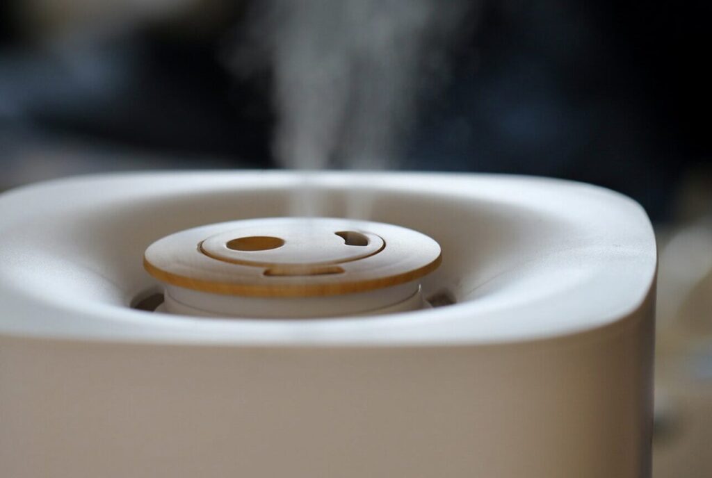 卓上型の加湿器を上部から見た構図で、吹き出し口から細かなミストが立ち上り、運転中であることがわかる状態を捉えた様子