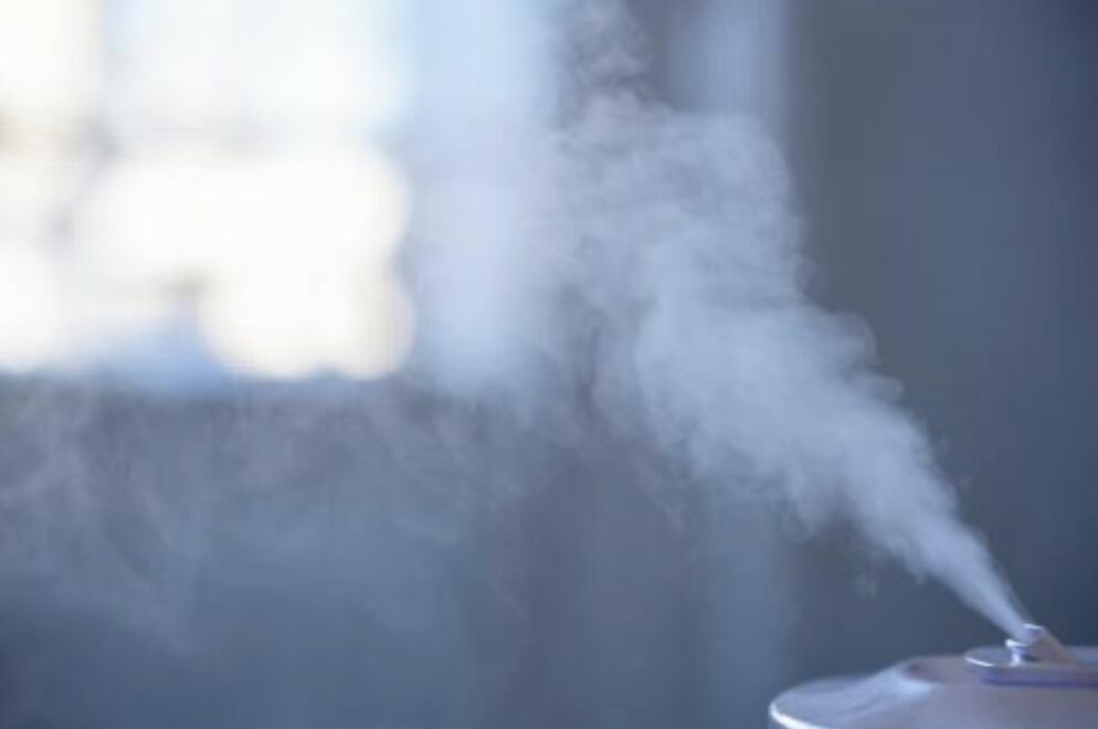 加湿器の吹き出し口から細かいミストが勢いよく噴き出し、室内に広がっていく様子をクローズアップで捉えた場面。