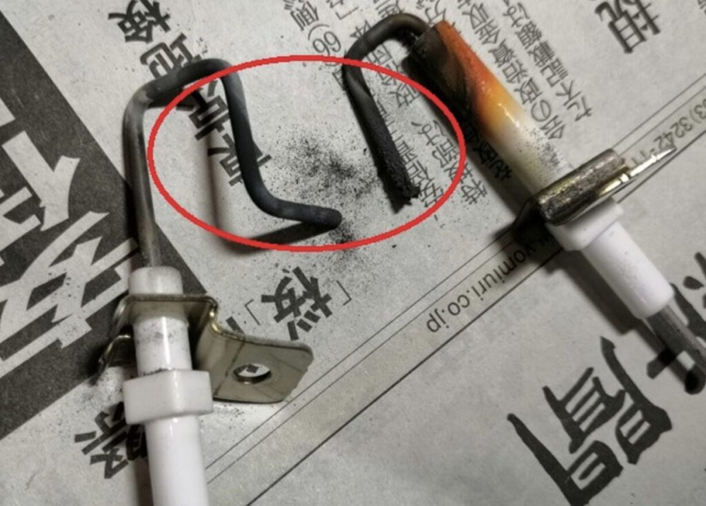 コロナ製石油ファンヒーターのフレームロッド先端を比較した様子。左側は正常な状態の金属ロッド、右側は先端部が焼損・劣化して欠損しており、周囲に黒い煤や粉状の付着物が確認できる。赤い円で劣化部分が強調されている構図。