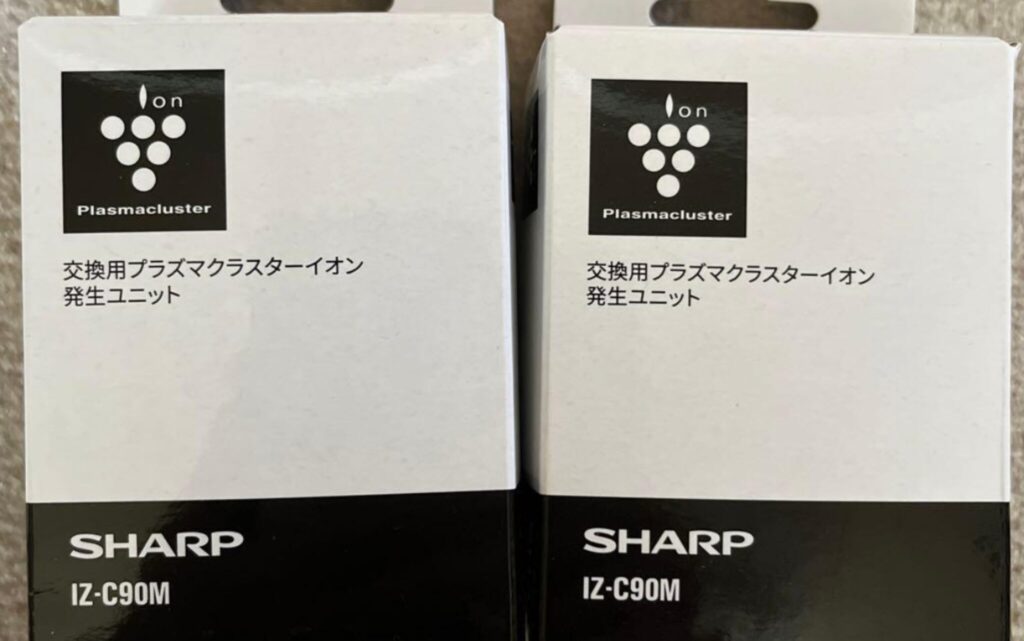 シャープ製プラズマクラスターイオン発生ユニットの交換用パッケージを並べて撮影した様子。白と黒のツートンデザインの箱正面に「Plasmacluster」ロゴと「交換用プラズマクラスターイオン発生ユニット」と記載があり、下部に型番「IZ-C90M」とSHARPロゴが表示されている。