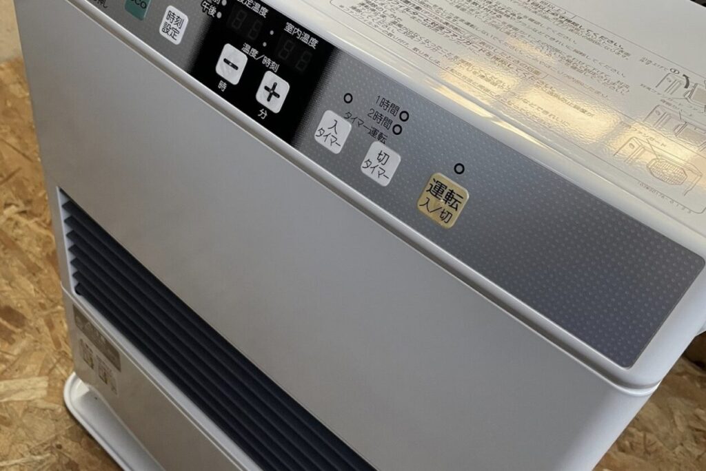 コロナ製石油ストーブ上部の操作パネルを斜めから撮影した様子。運転入切、タイマー、温度調整ボタンと表示部が並んでいる。