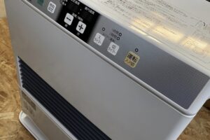 コロナ製石油ストーブ上部の操作パネルを斜めから撮影した様子。運転入切、タイマー、温度調整ボタンと表示部が並んでいる。