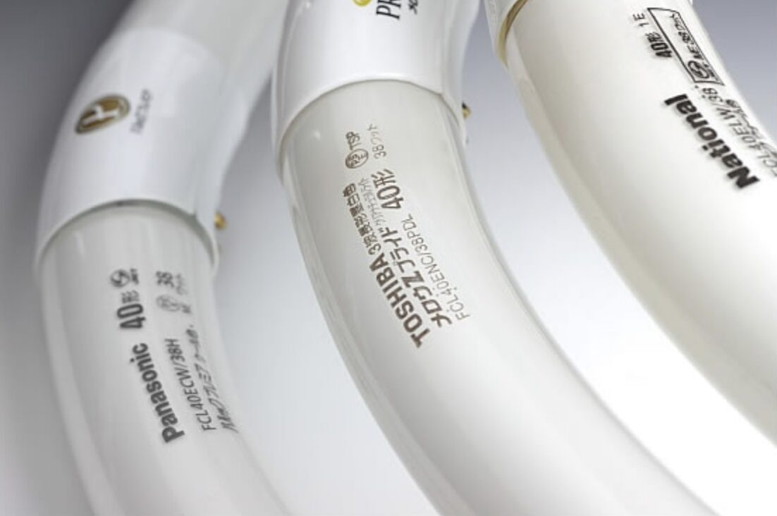 丸形蛍光灯のガラス管部分を拡大した様子。PanasonicやTOSHIBAのメーカー名、40形などの型番・仕様表示が印字されている。