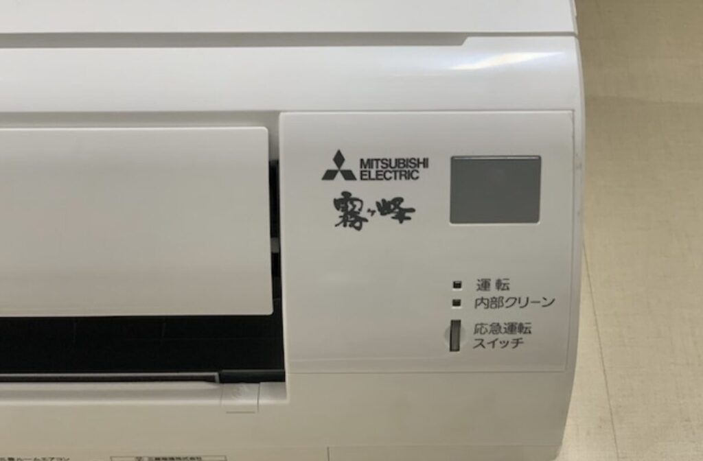 三菱電機製エアコンの右側操作パネル部分を拡大し、ロゴや運転ランプ、スイッチ表示が確認できる様子。