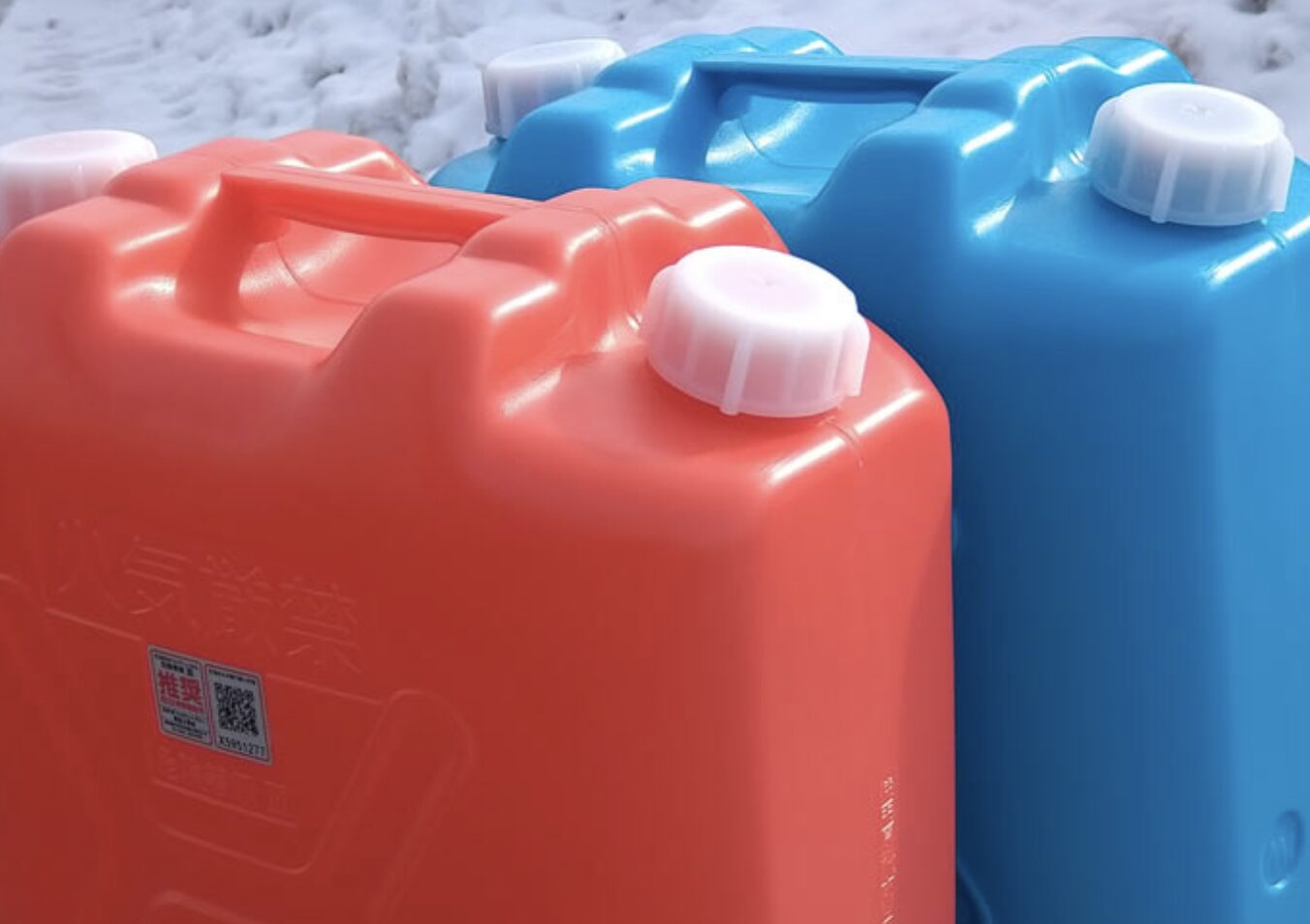 赤色と青色の灯油用ポリタンクが並んで置かれている様子。白いキャップと持ち手部分がはっきり見える構図で、屋外の明るい環境で撮影されている。