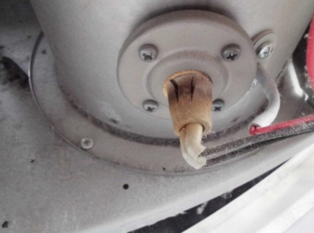 ストーブ底部に取り付けられた点火ヒーターの先端部分。被覆が変色し、表面に劣化や焼け跡が確認できる。