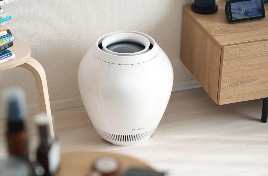 木製家具のそばに設置された、丸みのある白色デザインの気化式加湿器が置かれた室内インテリアの一部。