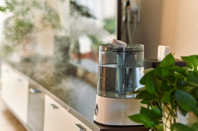 透明な水タンクを備えた加湿器から細かな加湿ミストが広がり、キッチンカウンター上で稼働している室内の様子。