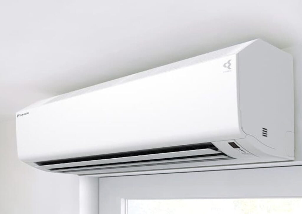 窓の上部に設置されたダイキン製の壁掛けエアコン室内機。白色の筐体で、室内になじむ設置例。