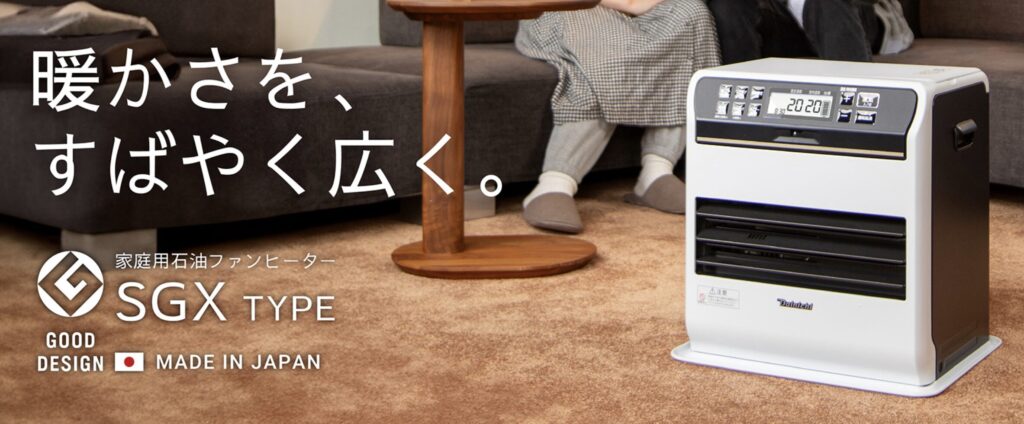 リビングの床に設置されたダイニチ製石油ファンヒーターSGX TYPE。ソファのそばで暖房運転され、室内を暖めている使用イメージ。