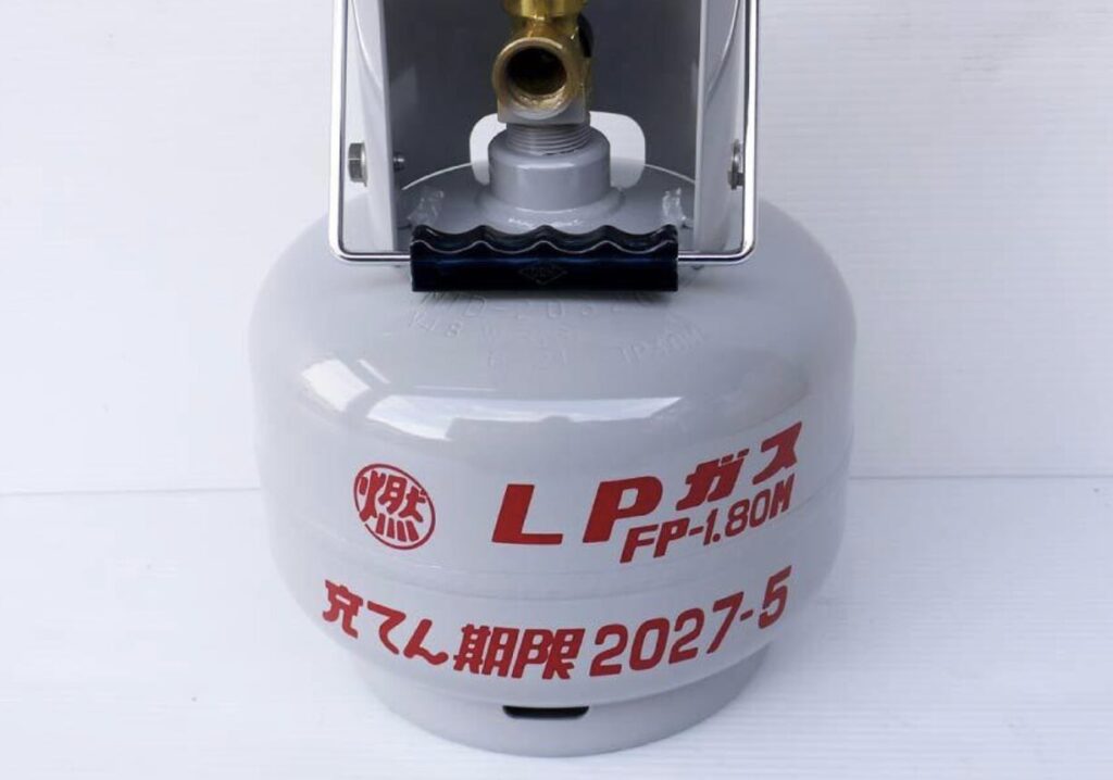 LPガスボンベ単体を正面から撮影した写真。容器表面にLPガス表示と充てん期限の記載が確認できる。