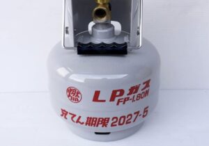 LPガスボンベ単体を正面から撮影した写真。容器表面にLPガス表示と充てん期限の記載が確認できる。