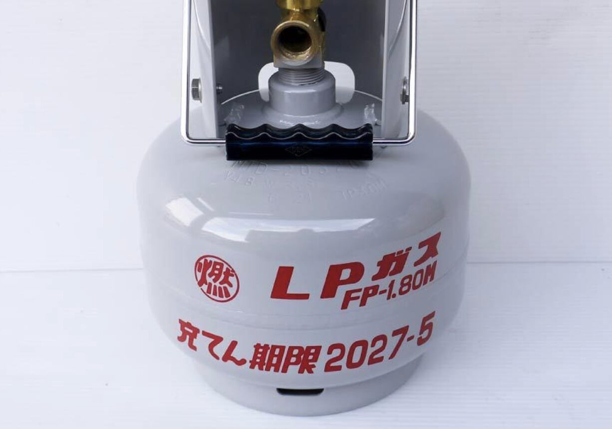 LPガスボンベ単体を正面から撮影した写真。容器表面にLPガス表示と充てん期限の記載が確認できる。