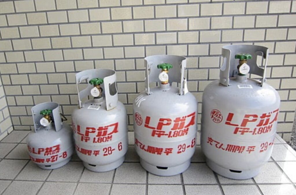容量の異なる複数のLPガスボンベが小さい順に並べて設置されている様子。容器ごとの大きさの違いが分かる。