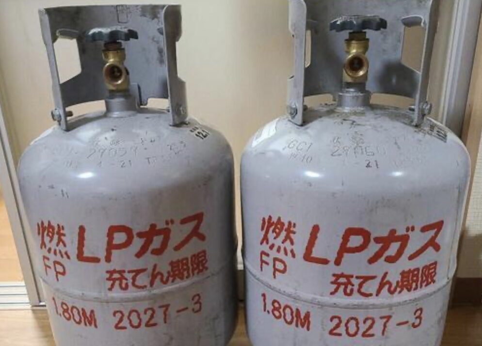 室内に並べて設置された2本のLPガスボンベ。表面に充てん期限や識別表示が記載されている。