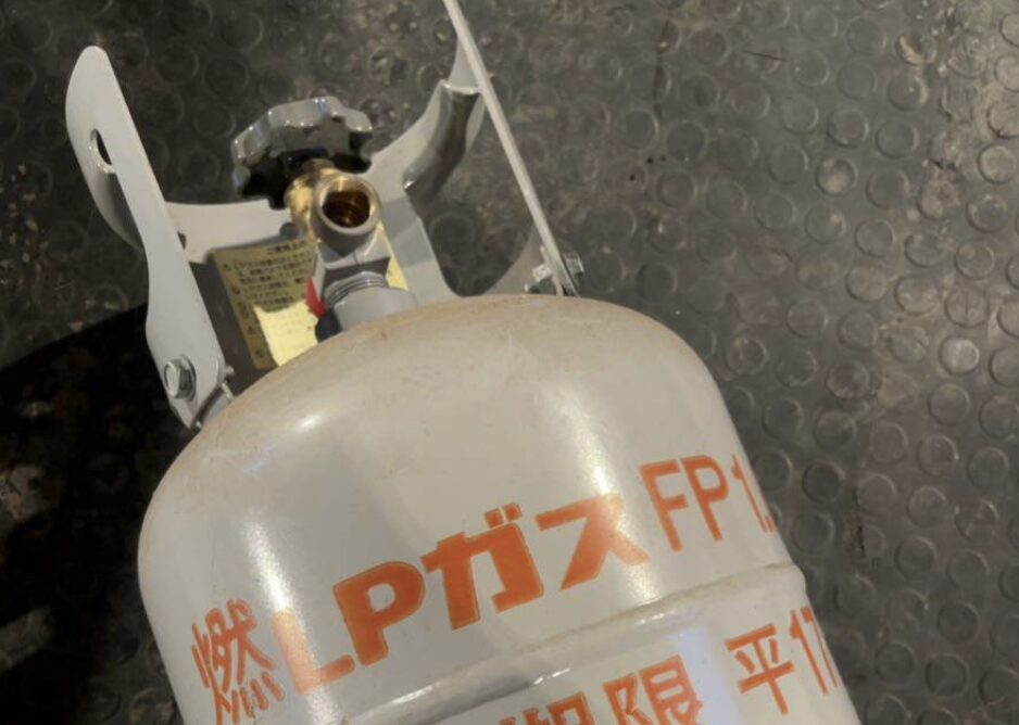 LPガスボンベの上部バルブと保護カバー部分を上から撮影した様子。バルブ開口部が露出している状態。