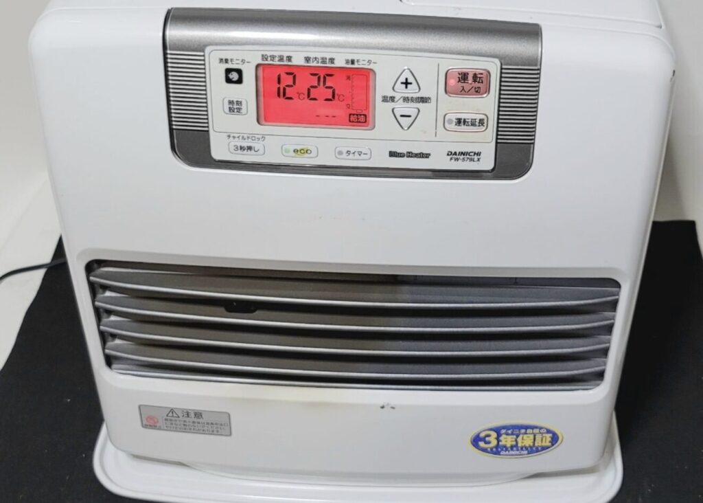 ダイニチ製石油ファンヒーターの操作パネルを正面から撮影した様子。赤色の液晶画面に設定温度と室内温度が表示されている。