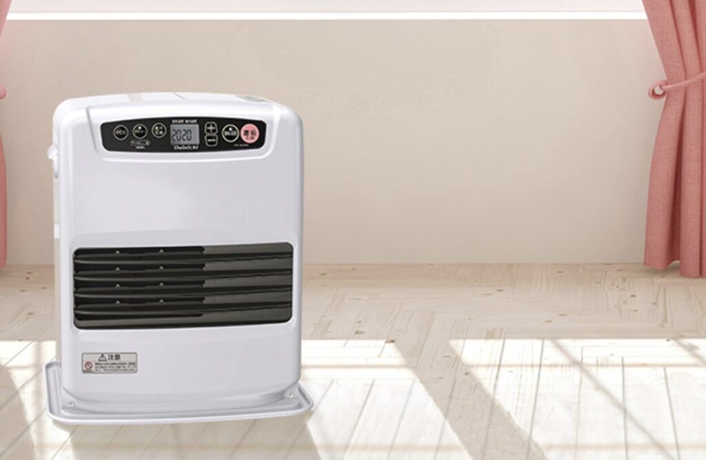 明るい室内に設置された白色の石油ファンヒーター。床の上に安定して置かれ、操作パネルが見える状態。