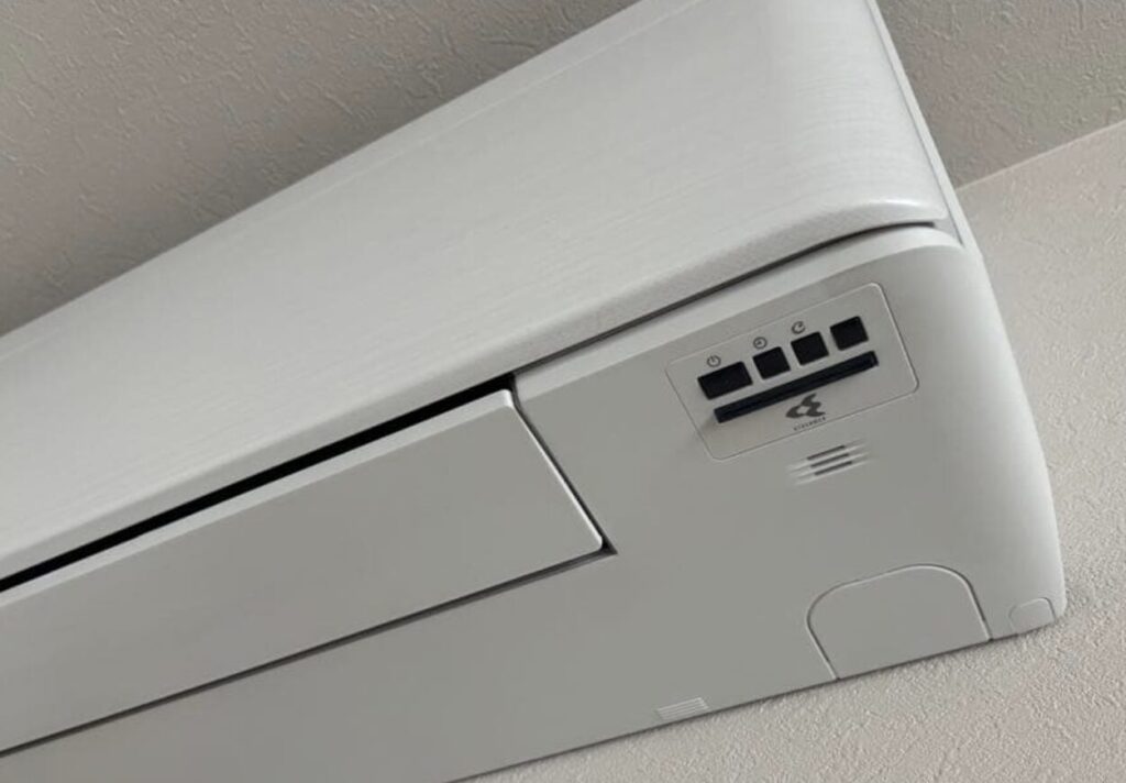 エアコン室内機の右側操作部を拡大した写真。運転ランプと操作ボタンが配置されている様子。