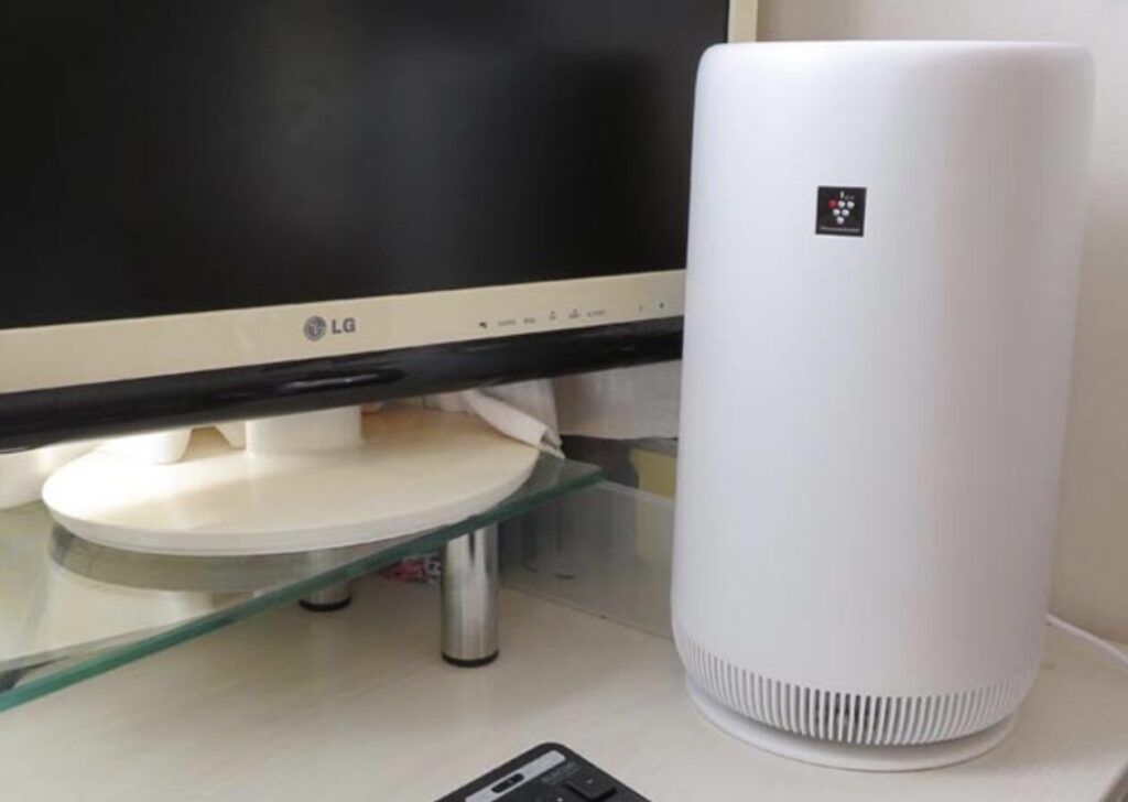 デスク横に設置された縦型の空気清浄機。パソコンモニターの近くに置かれ、省スペースで使用されている様子。