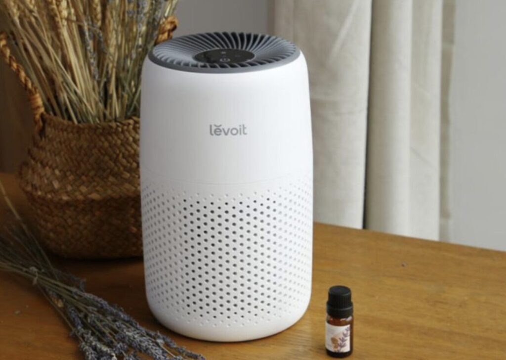 木製テーブルの上に設置された白色の小型空気清浄機。側面に通気孔があり、室内インテリアとして配置されている。