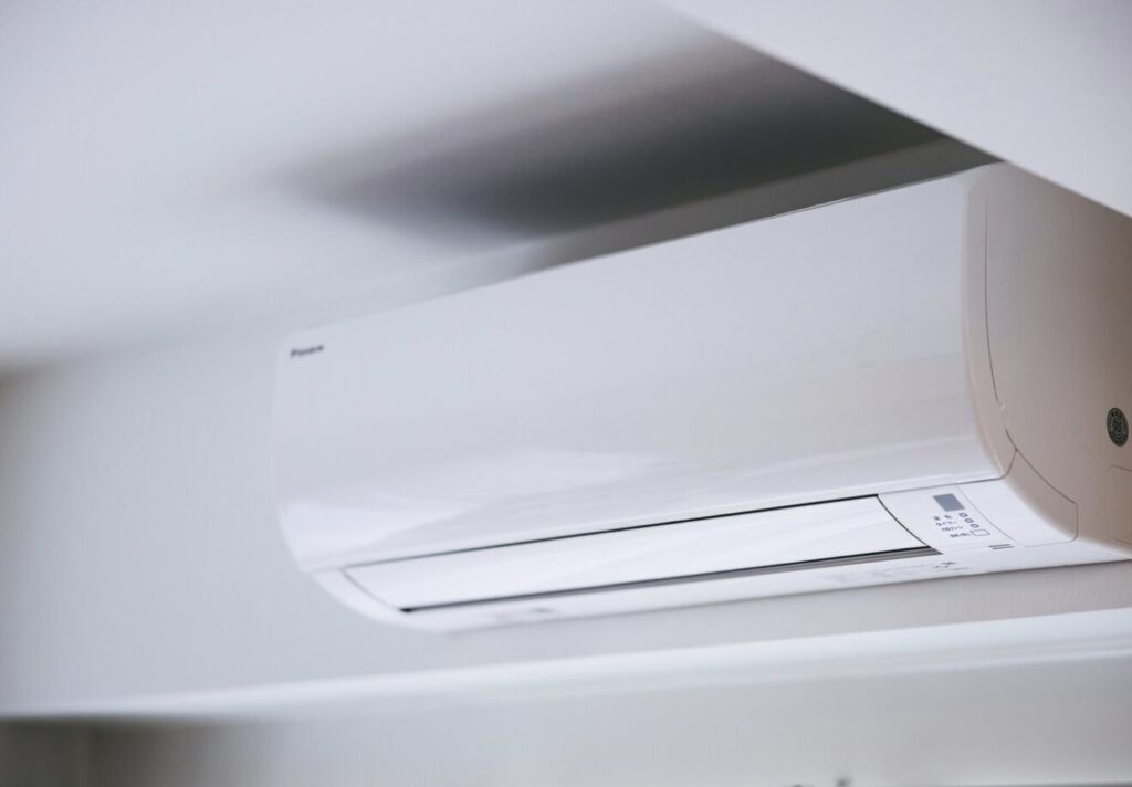 室内の壁面上部に設置されたルームエアコンの室内機。天井との距離が近く、一般的な壁掛け設置状況が分かる。