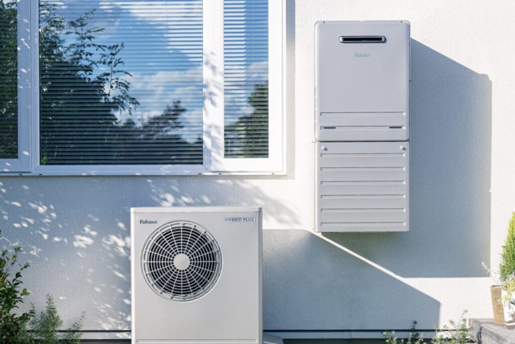 住宅外壁に設置されたパロマ製の給湯器とヒートポンプユニット。窓の下に室外機が配置され、給湯システム一式の設置状況が確認できる。