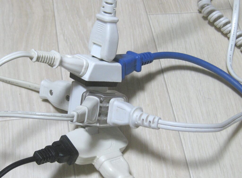 分岐タップを重ねて使用し、多数の電源プラグが集中して接続されている状態
