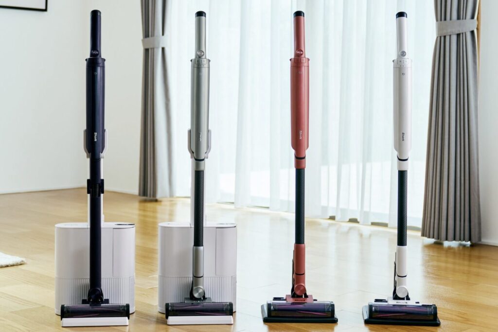 Shark製コードレス掃除機のカラーバリエーションが4色並び、室内に設置されている様子