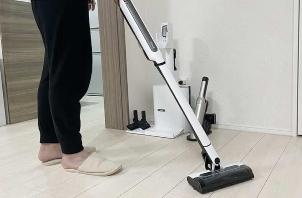 Shark製コードレス掃除機を使い、室内のフローリングを掃除している使用シーン