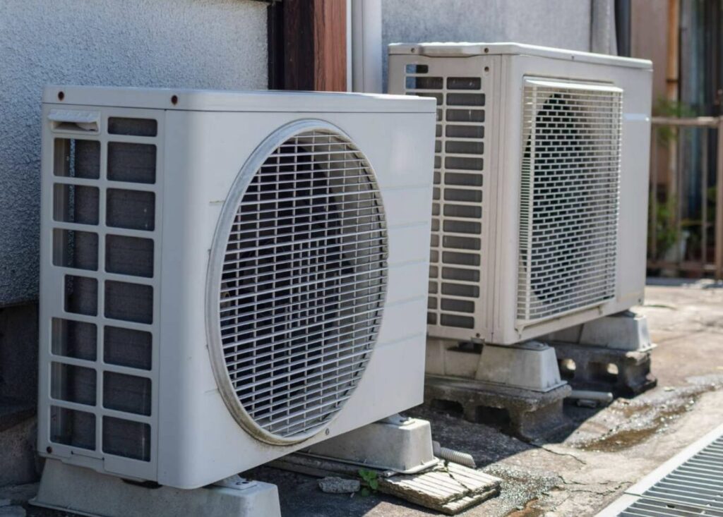 建物外壁沿いに並んで設置された複数台のエアコン室外機の様子