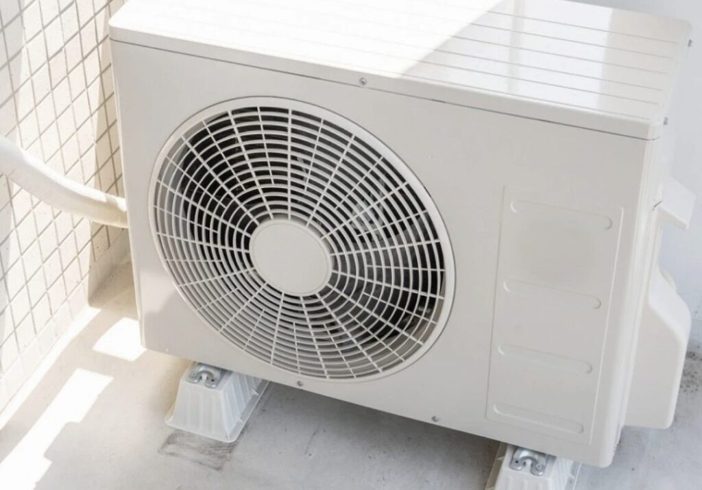 直射日光が当たるベランダに設置されたエアコン室外機と配管の取り回し