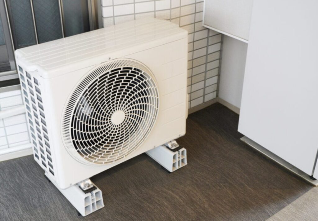 ベランダの床に防振架台で設置された家庭用エアコン室外機の設置状況