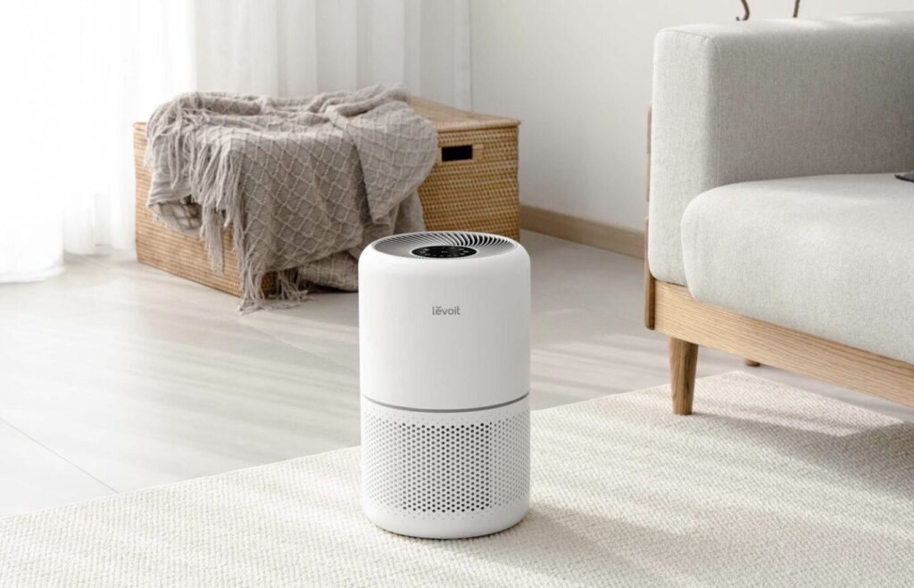 リビングの床に置かれた円筒型空気清浄機と、ソファや収納ボックスがある落ち着いた室内空間