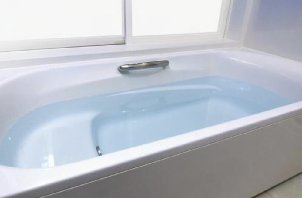 自動湯はりでお湯が張られた浴槽。透明な湯面と白い浴槽内部が見える状態。