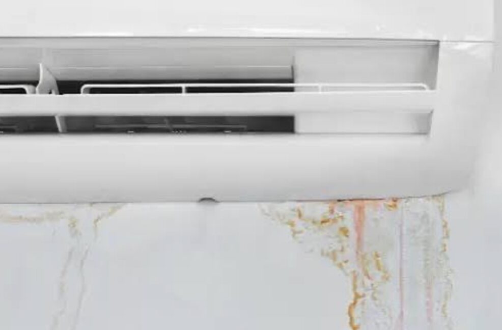 エアコン本体の吹き出し口下から水が垂れ、壁紙に水染みが広がっている様子
