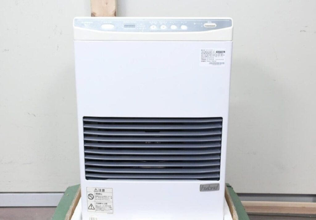 正面から見たサンポット製の白いFF式石油ストーブ本体。前面に横ルーバーの温風吹き出し口がある構造