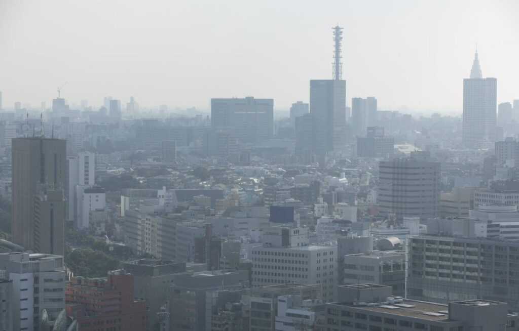 黄砂でかすみ遠景のビル群が白くぼやけて見える都市の風景