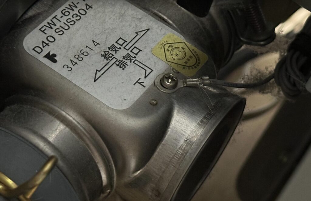 FF式ストーブ内部の給排気接続部。給気口・排気口の表示ラベルと検知リード線の固定部分の接写