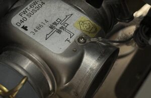 FF式ストーブ内部の給排気接続部。給気口・排気口の表示ラベルと検知リード線の固定部分の接写